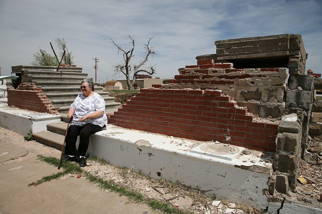 55. Woman sitting on steps of destroyed church, Greensburg 9